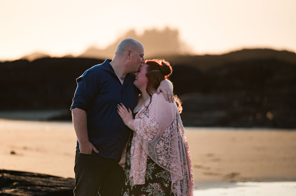 Couple kisses on the beach in Tofino BC for engagement photography session